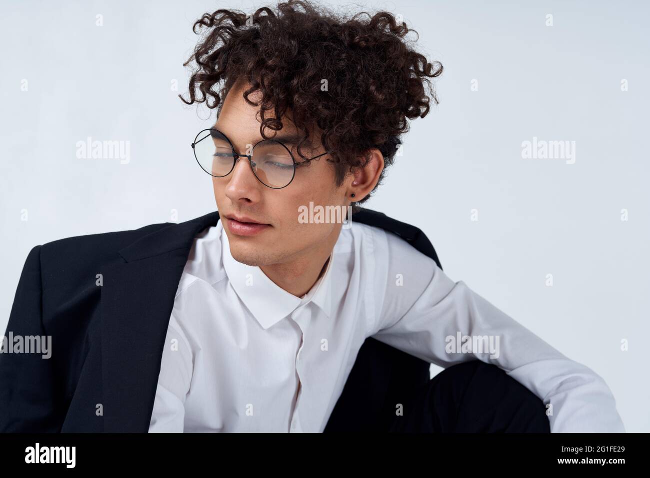 curly guy classic suit glasses cropped view light background portrait ...