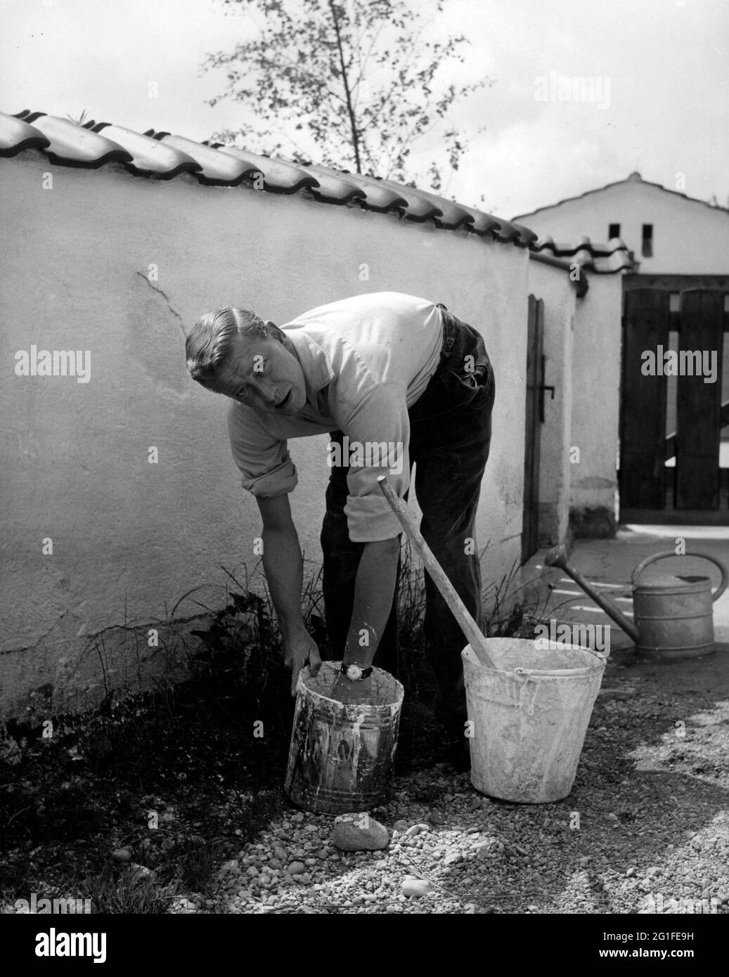 Borsche, Dieter, 25.10.1909 - 8.5.1982, German actor, full length, at home, painting garden wall, ADDITIONAL-RIGHTS-CLEARANCE-INFO-NOT-AVAILABLE Stock Photo