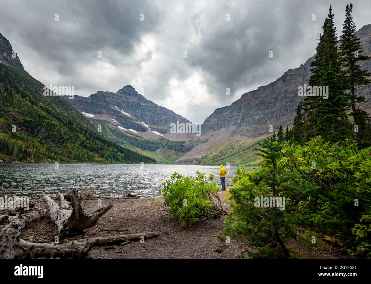 Hikers at Upper Two Medicine Lake, mountain peak Lone Walker Mountain in the back, dramatic clouds, Glacier National Park, Montana, USA Stock Photo