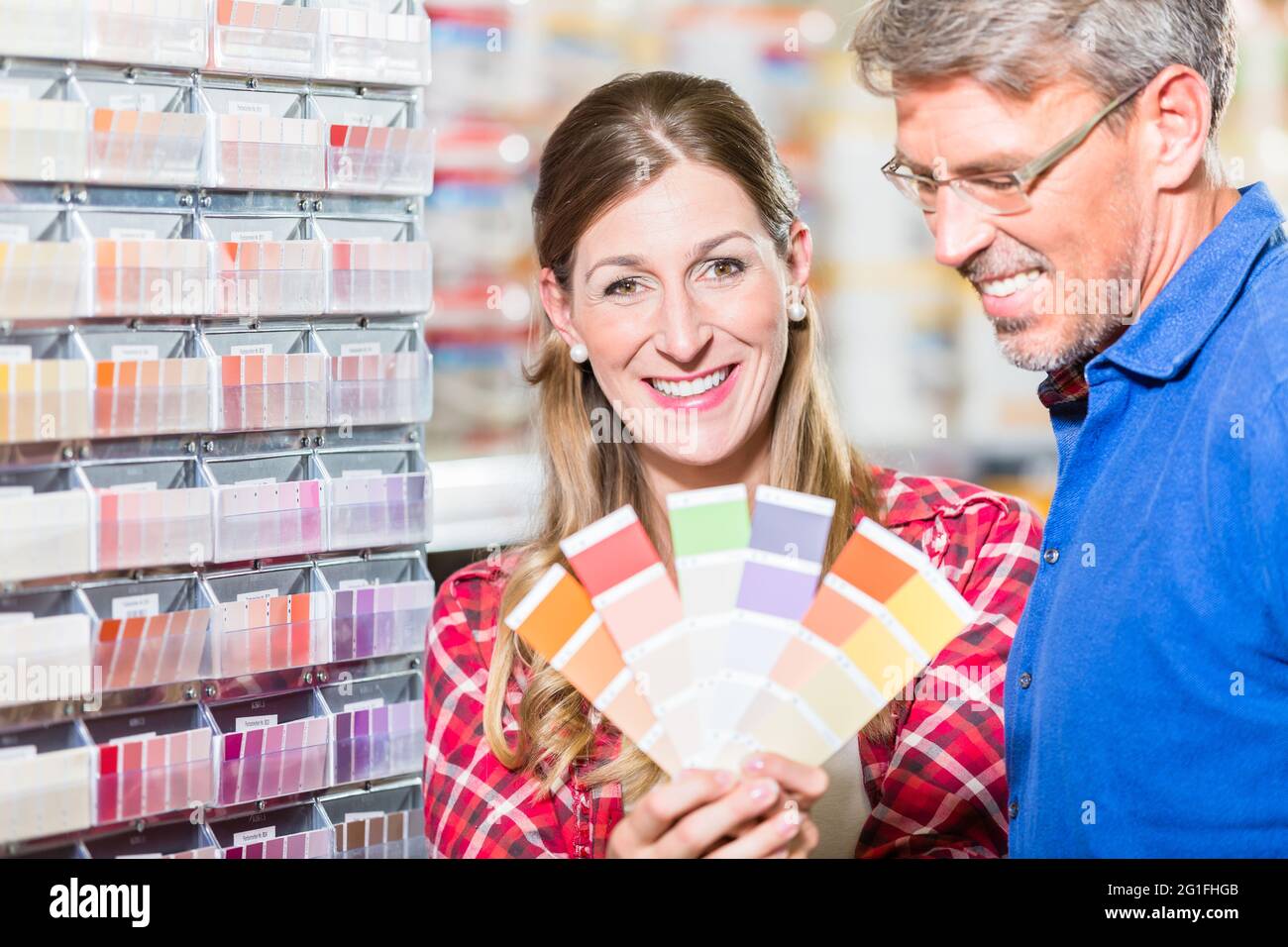 Couple, woman and man, choosing color of wall paint in decoration department of hardware store Stock Photo