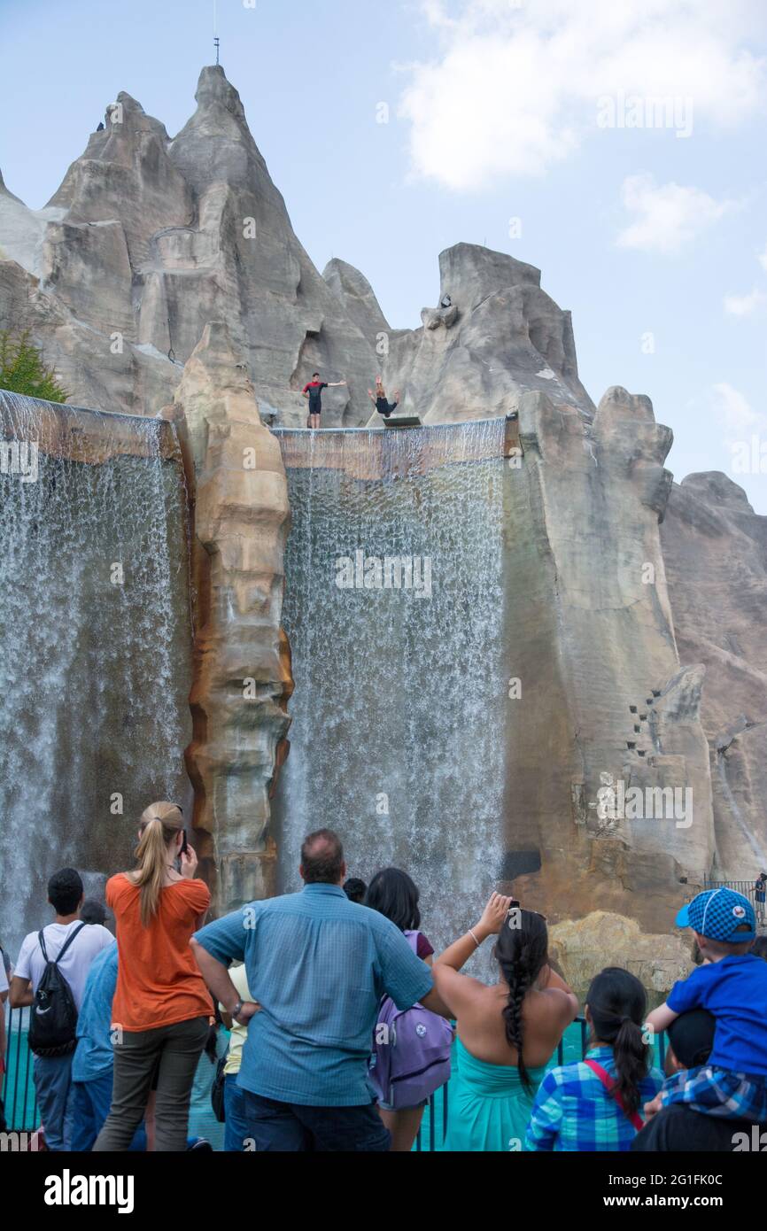 Spectators watch the show with jumping into the water from a height. People having fun on the weekends. Stock Photo