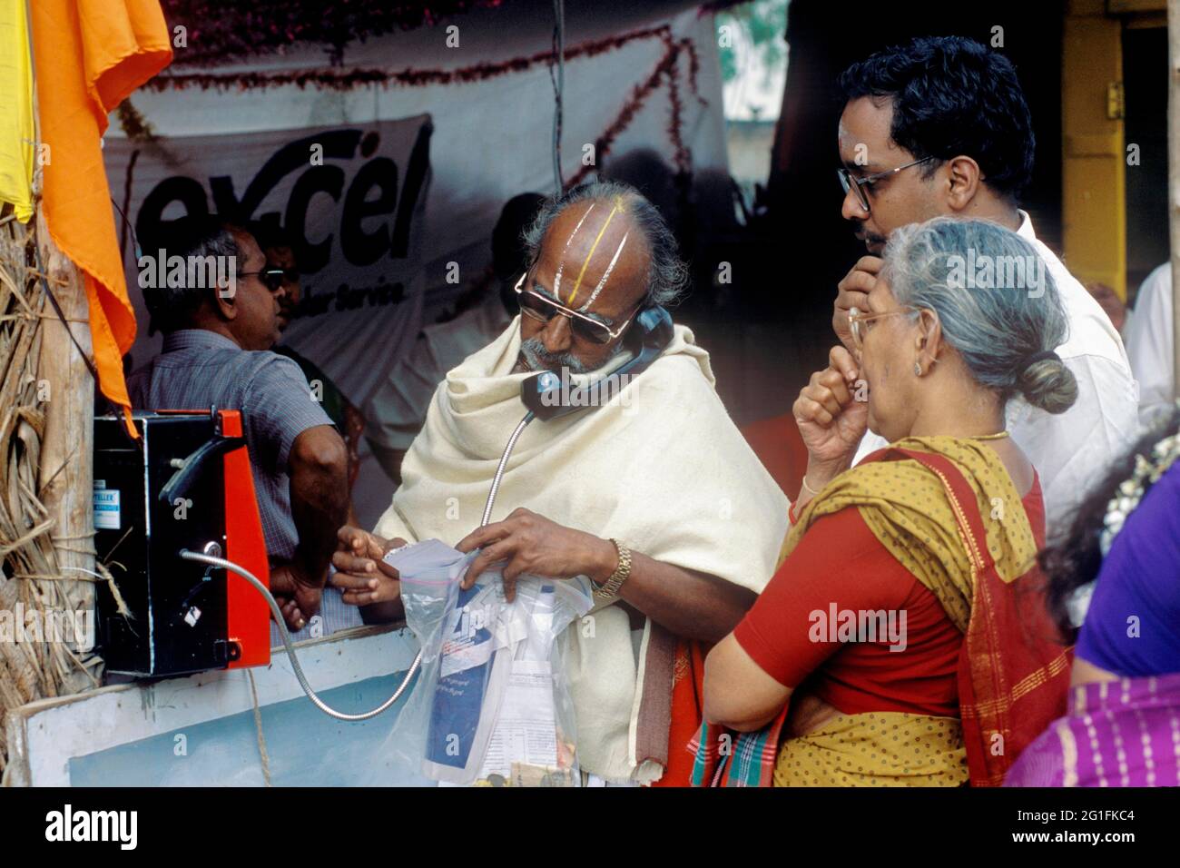 Ein Brahmane spricht am oeffentlichen Festnetztelefon waehrend des Thyagaraja Aradhana Festivals in Thiruvaiyaru in der Naehe von Thanjavur, Tamil Stock Photo