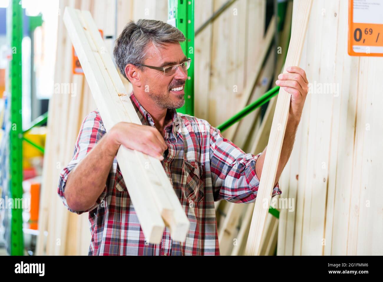 Customer in lumber department of hardware store choosing wood strip for