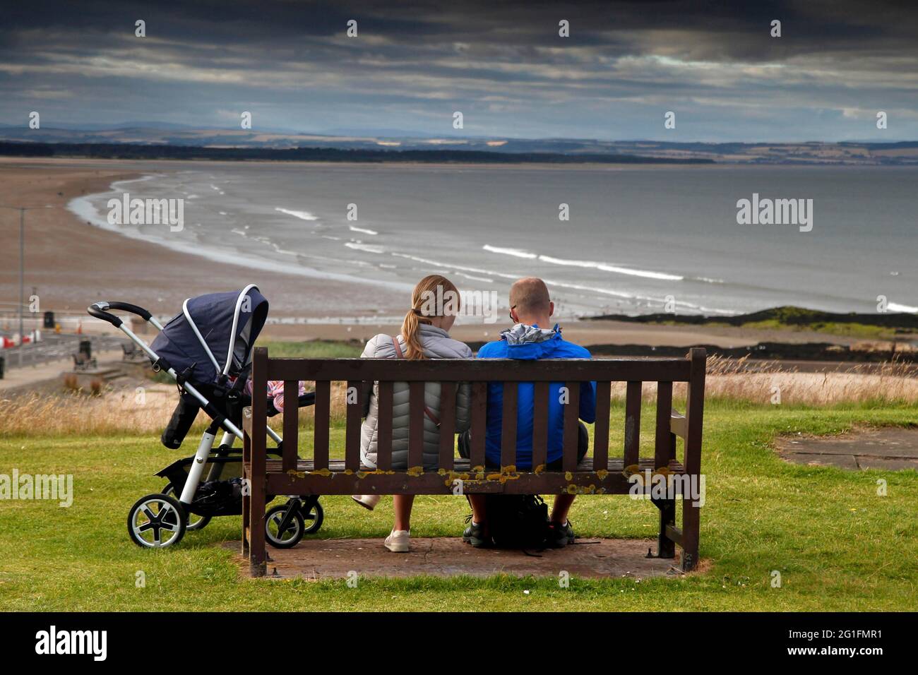 Beach, bench, couple with pram, St Andrews, Fife, Midlands, Central Scotland, Scotland, United Kingdom Stock Photo