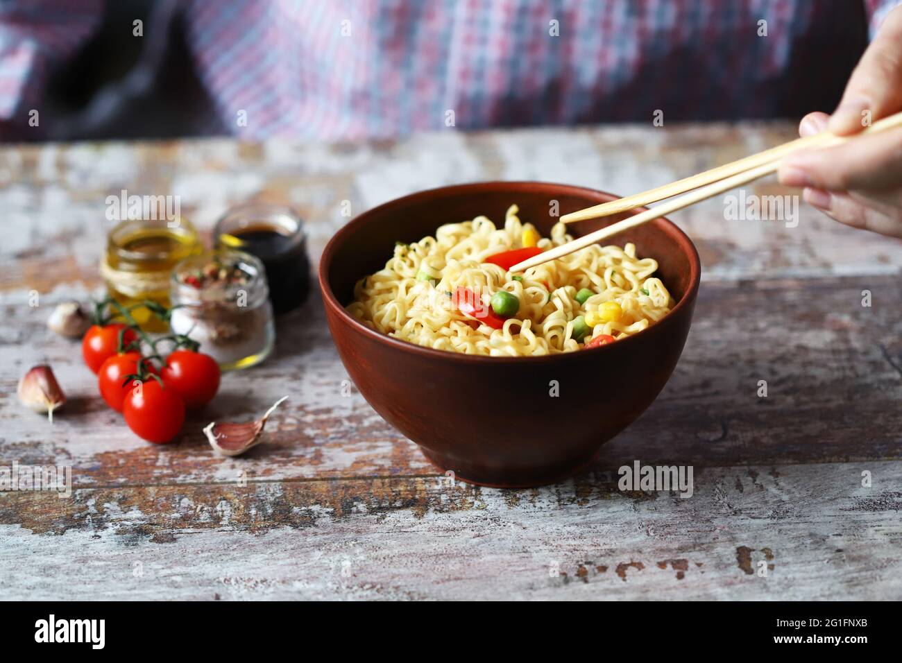 Male hands are eating Chinese noodles with chopsticks. Chinesestyle