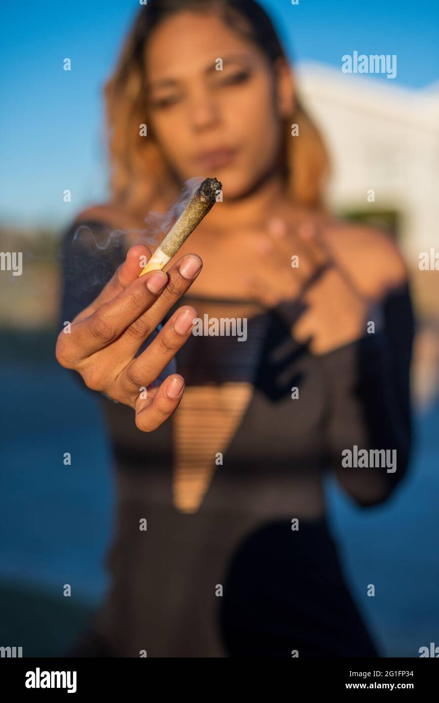 Woman showing her marijuana filled cigarette Stock Photo