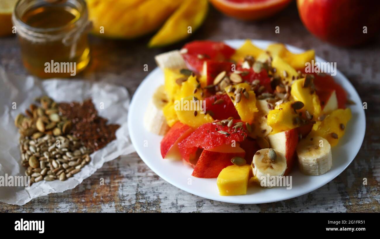Super fresh nutritious fruit salad with seeds. Salad with mango, banana and grapefruit. Vitamin food. Healthy food. Stock Photo