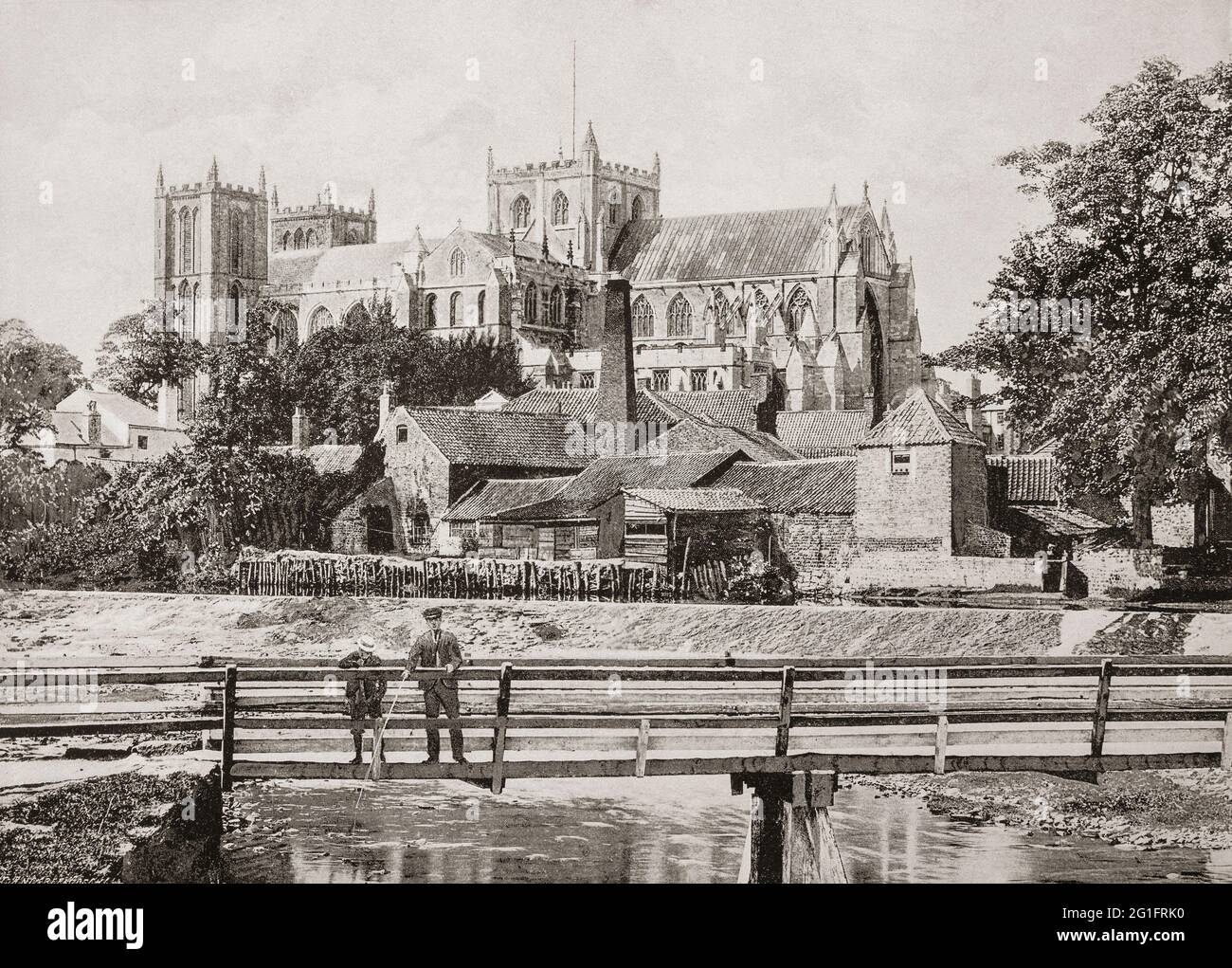 A late 19th century view of the Cathedral Church of St Peter and St Wilfrid, commonly known as Ripon Cathedral in the North Yorkshire city of Ripon from across the River Skell. It was founded as a monastery by Scottish monks in the 660s, and  became collegiate in the tenth century, and acted as a mother church within the large Diocese of York for the remainder of the Middle Ages. The present church was built between the 13th and 16th centuries and became the cathedral for the Diocese of Ripon in 1836. Stock Photo