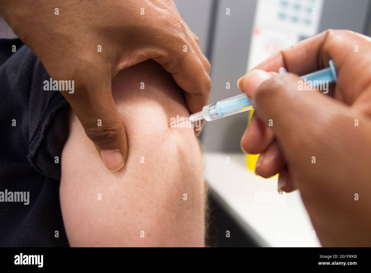AstraZeneca / Astra Zeneca covid 19 coronavirus vaccine being injected with a hypodermic syringe into the arm of a man in his 50's. London, UK. This is the second 2nd dose so the person will be fully vaccinated. (123) Stock Photo
