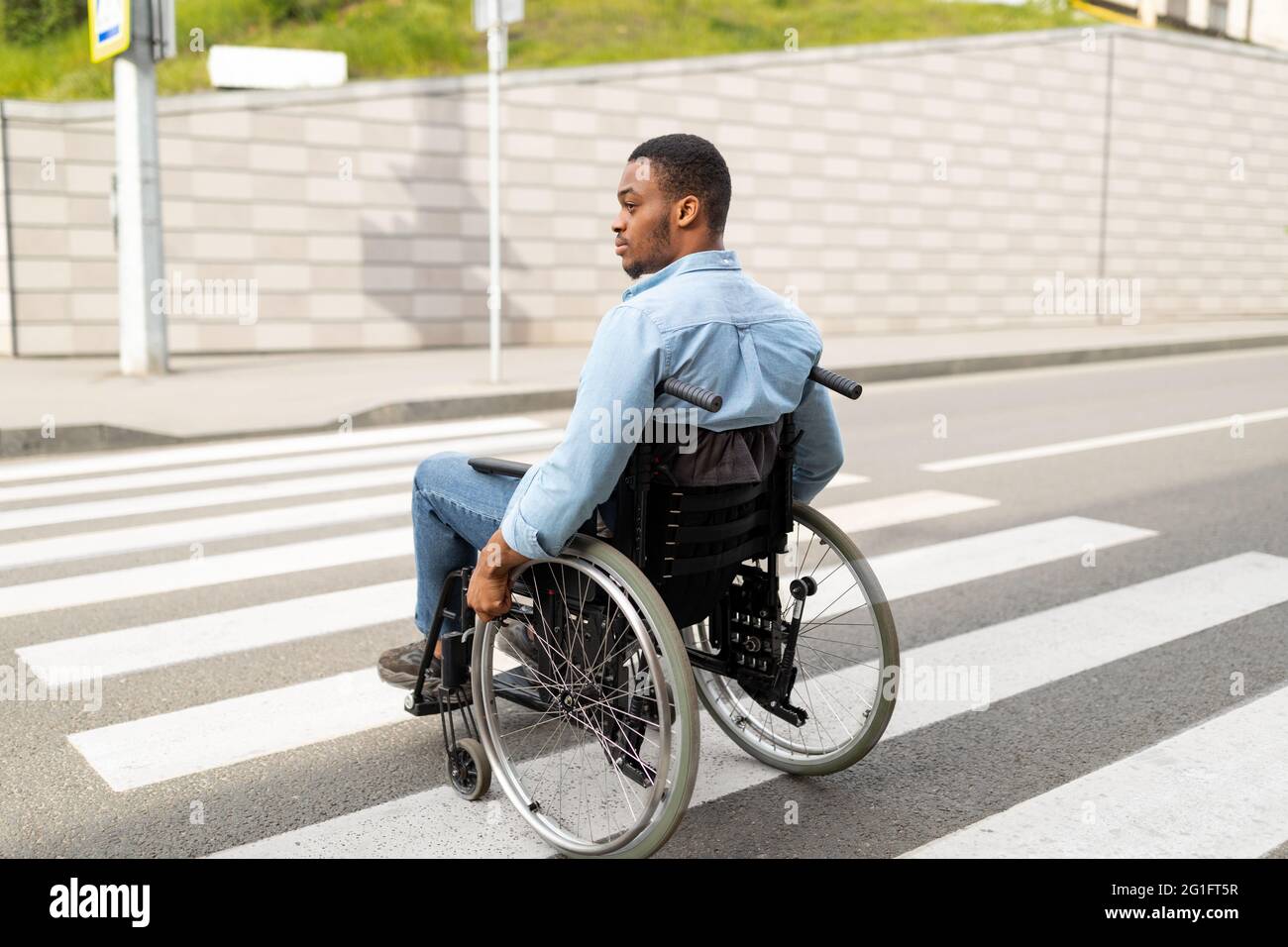 Young disabled black man in wheelchair using crosswalk outdoors. Quality of  life and impairment concept Stock Photo - Alamy