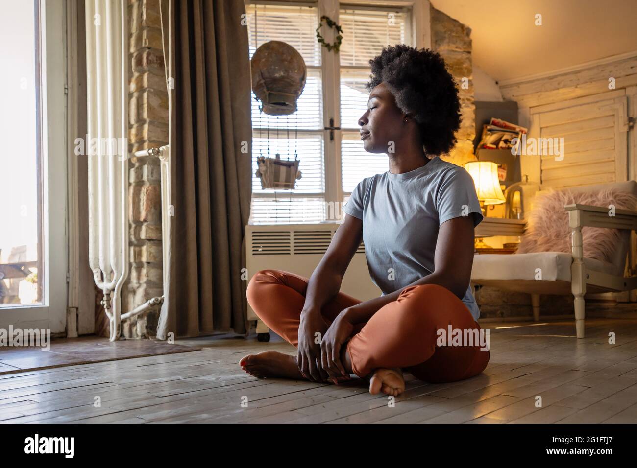 Health lifestyle and people concept. Portrait of peaceful young black woman meditating indoors Stock Photo