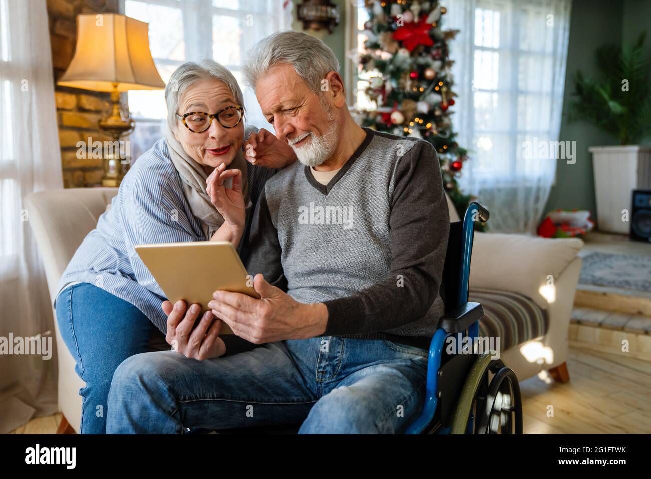Senior couple having fun and laughing while using their tablet pc computer. Stock Photo