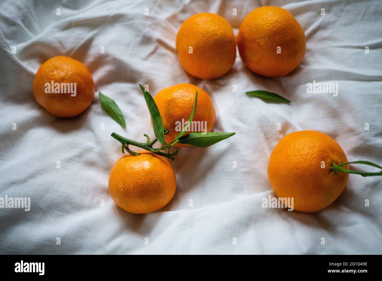 Clementine tangerines on the white bed sheet. Top view Stock Photo Alamy