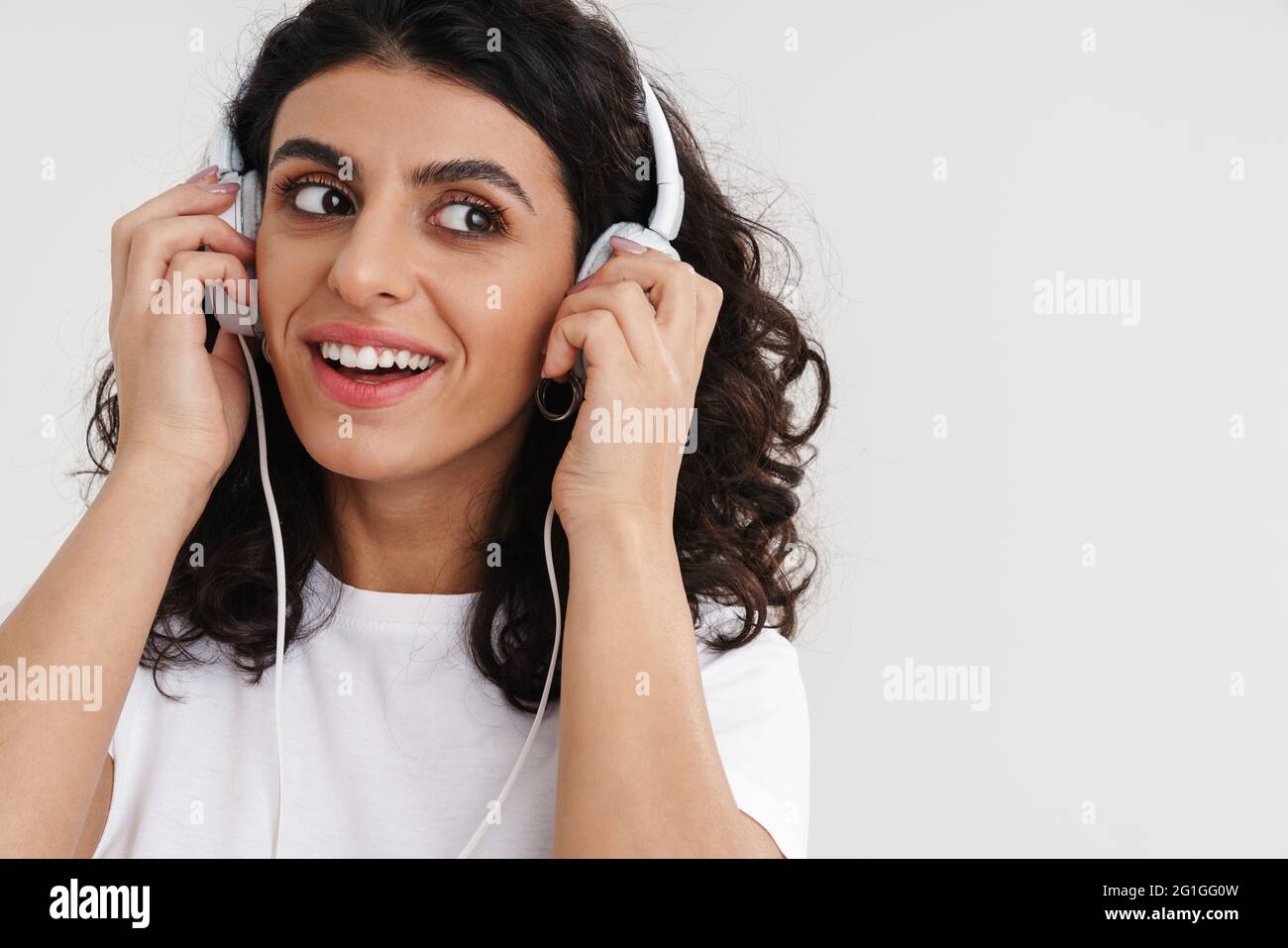 Happy brunette girl smiling while listening music with headphones ...