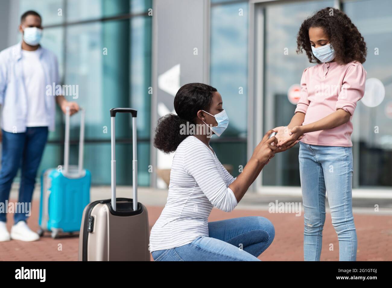Black family traveling with kid, using sanitizer Stock Photo - Alamy