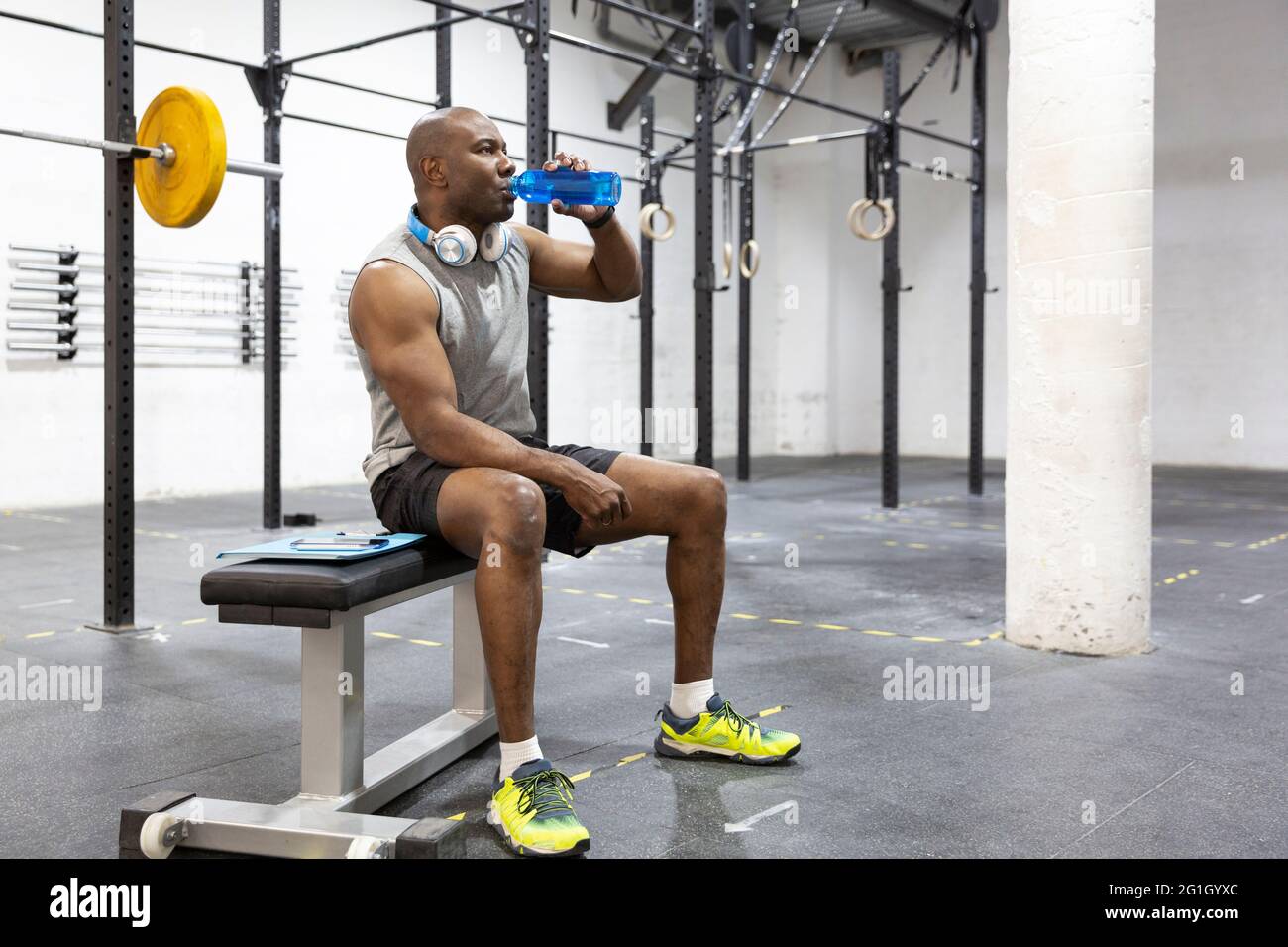 African American man hydrating after exercise in fitness center. Space for text. Stock Photo