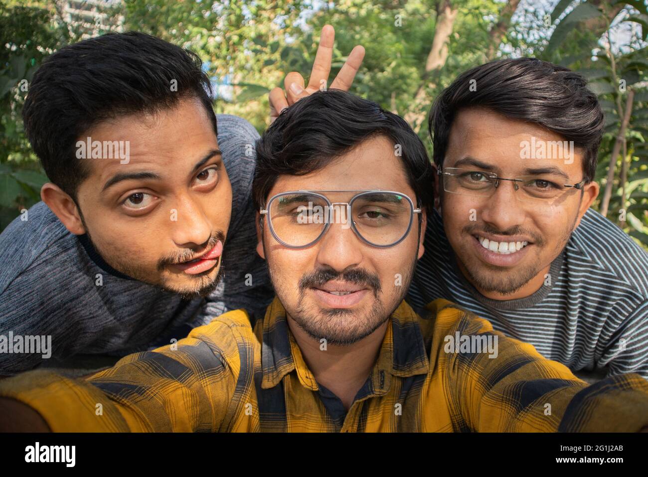 Group of young people grimacing in front of the camera - Young happy people having fun at park making funny faces while taking selfie - Concept of Stock Photo