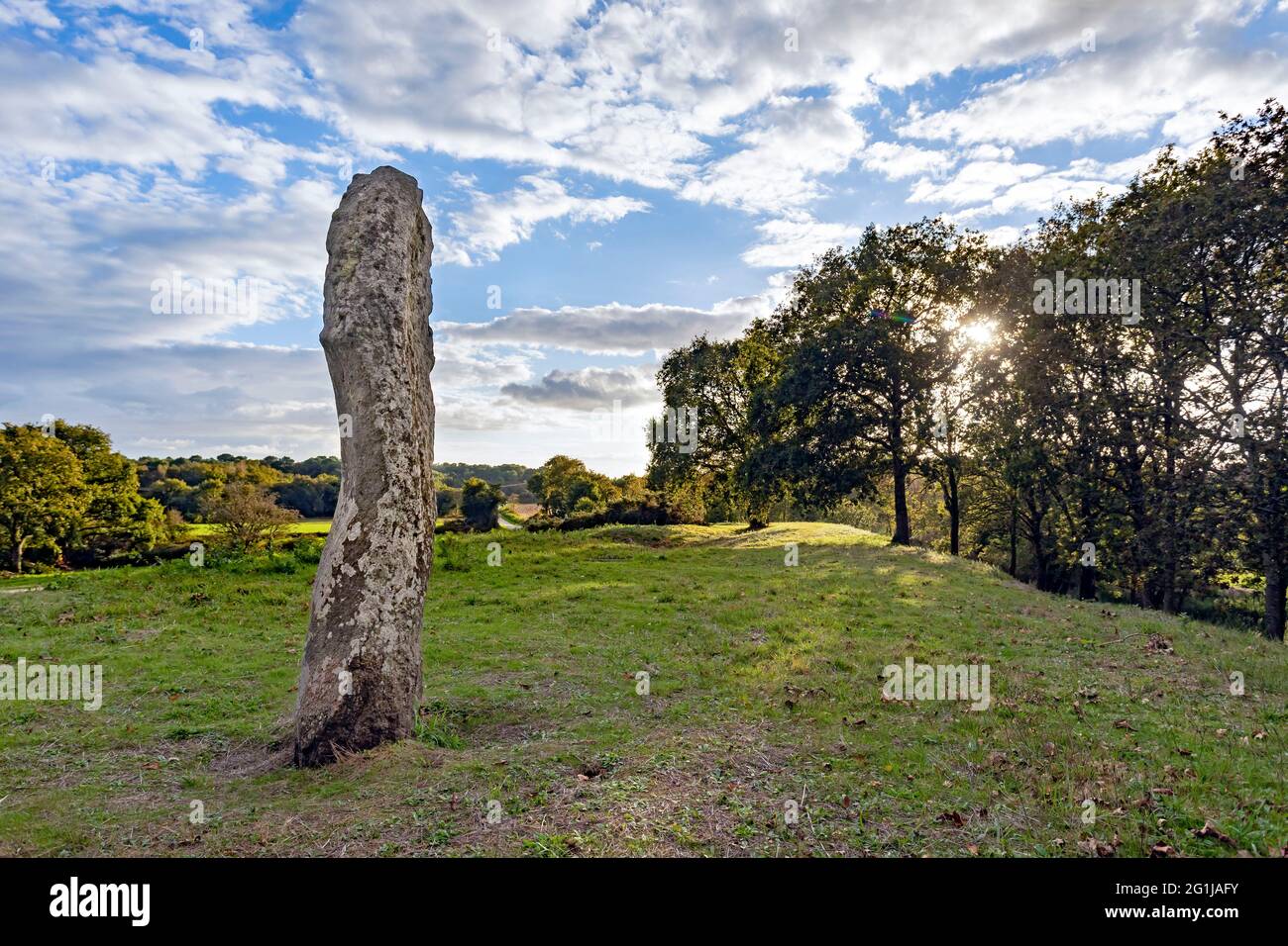 Carnac (Brittany, north western France): menhir (standing stone) atop the Moustoir chamber tomb or tumulus Stock Photo