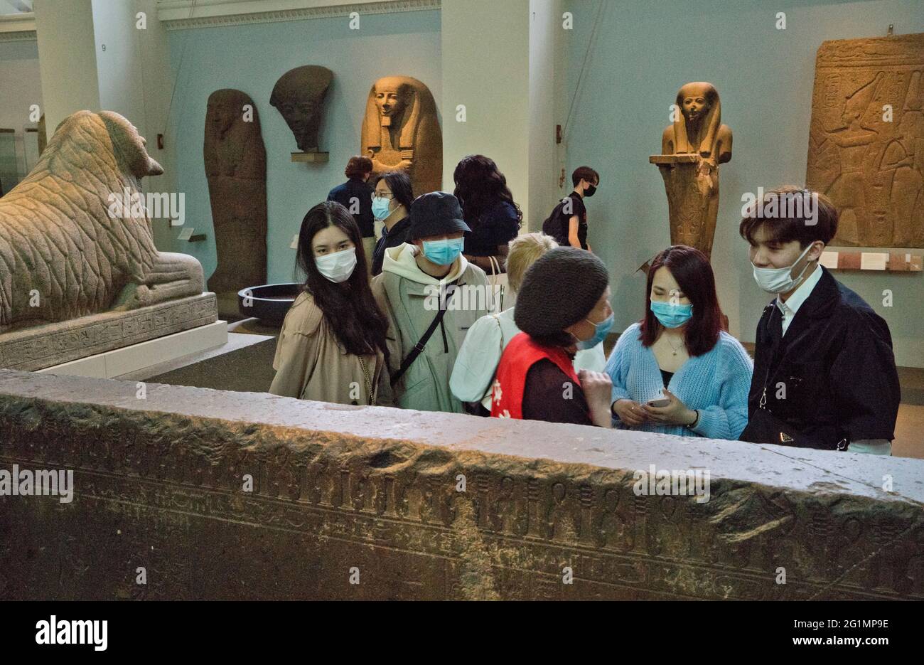 Tour guide and visitors to the British Museum in London,wearing masks ...
