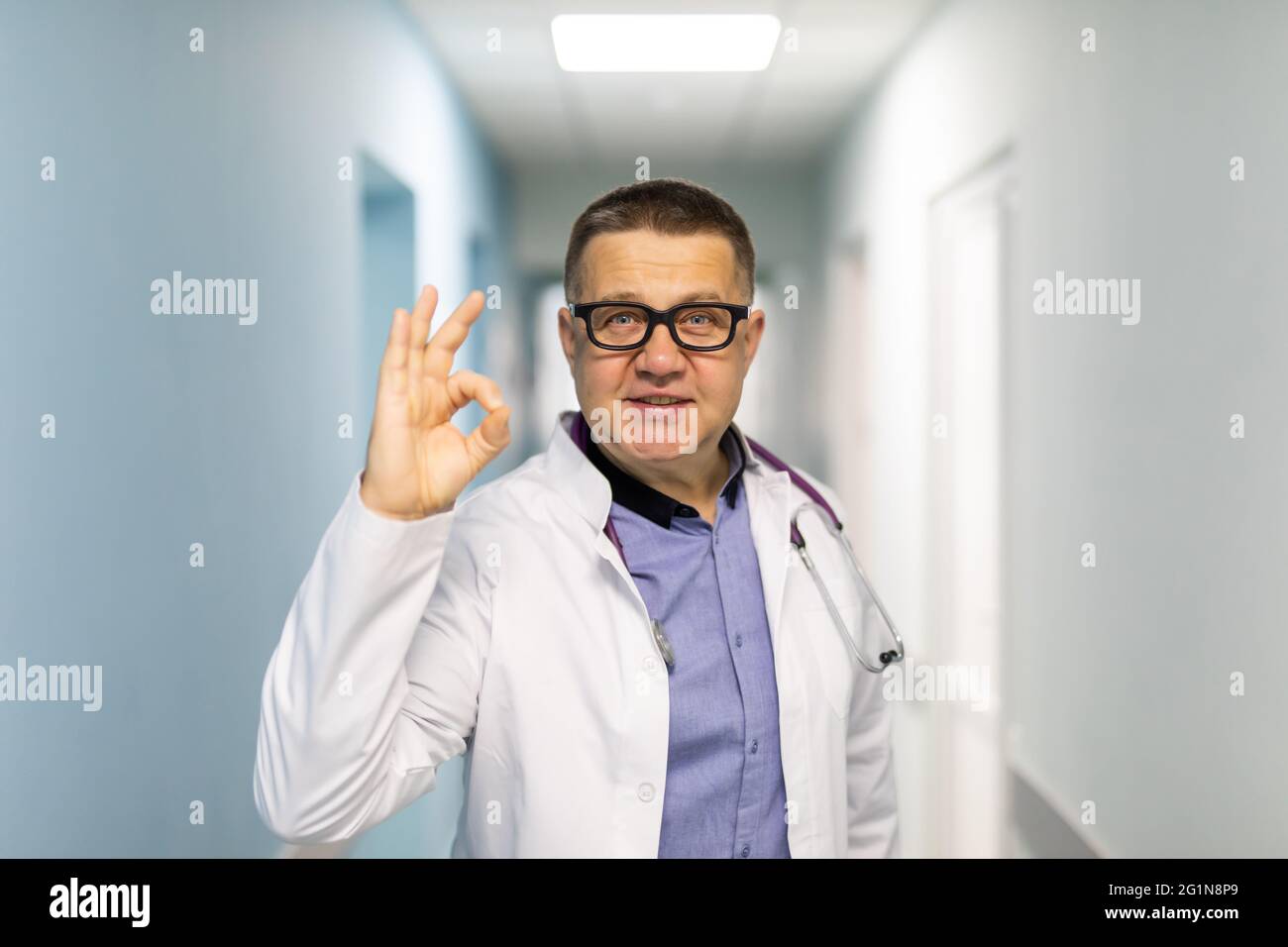 Happy male doctor is showing ok sign. Making circle with fingers. Gesture of approval. Stock Photo