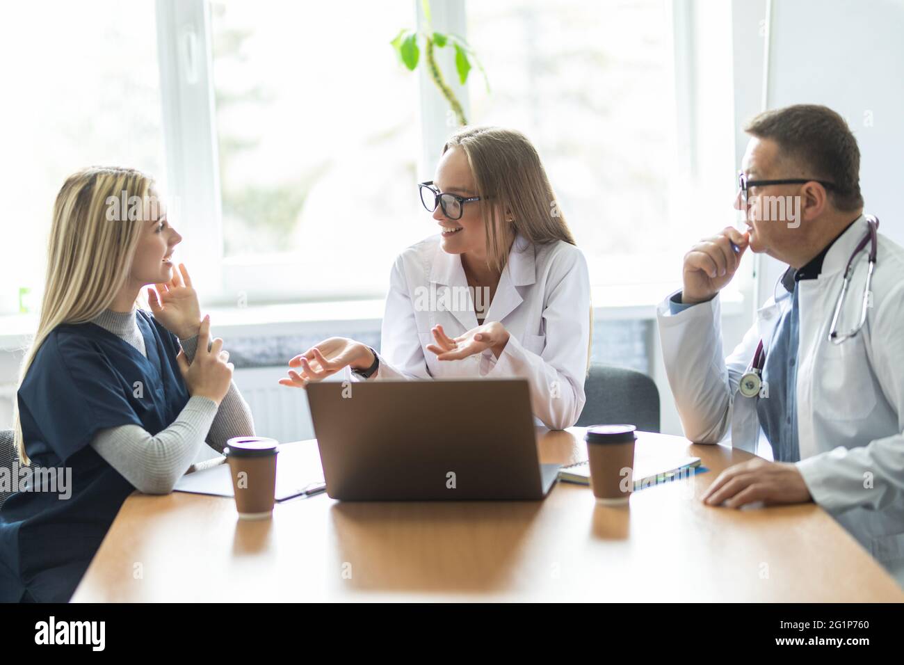 Medical team having a meeting with doctors in white lab coats and ...