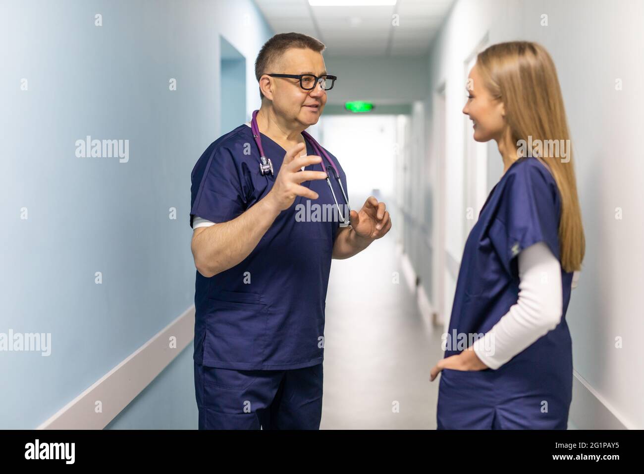 Two doctors discussing diagnosis while walking Stock Photo