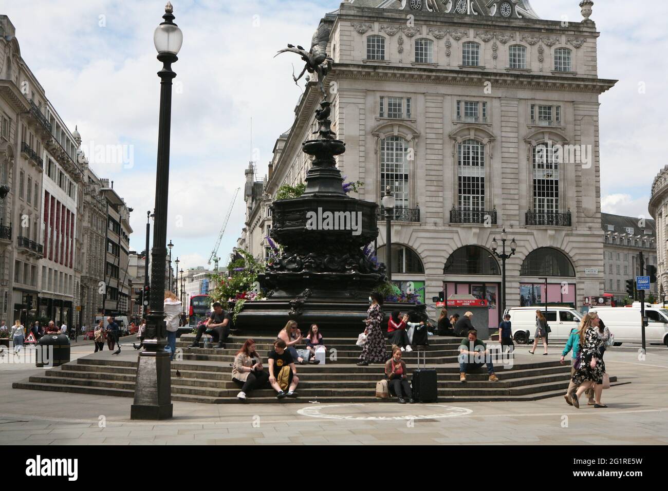 People enjoying the sunshine on the steps of the statue of Eros in Piccadilly Circus, London. Picture date: Monday June 7, 2021. Stock Photo