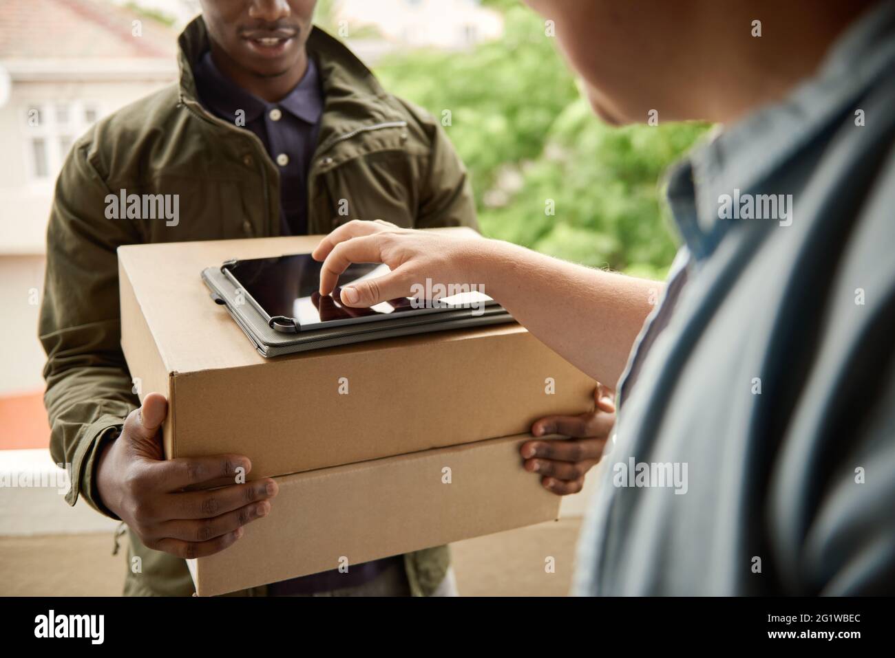 African courier getting a digital signature from a customer Stock Photo