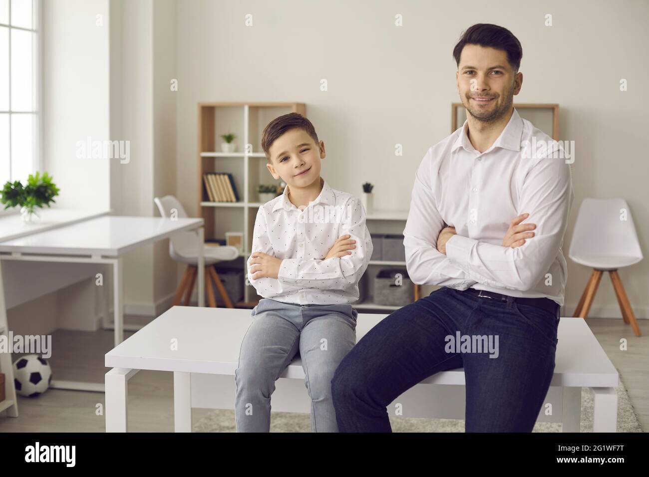 Happy smiling father and son in stylish formal wear posing for camera