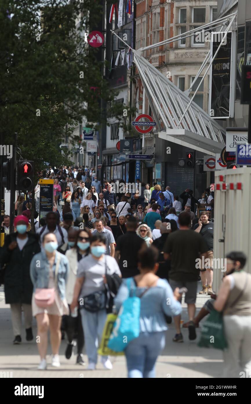 Some people wearing masks as they walk down busy Oxford Street, London following the further easing of lockdown restrictions in England. Covid-19 case rates are rising in more local areas of the UK than at any point since early January. Picture date: Monday June 7, 2021. Stock Photo