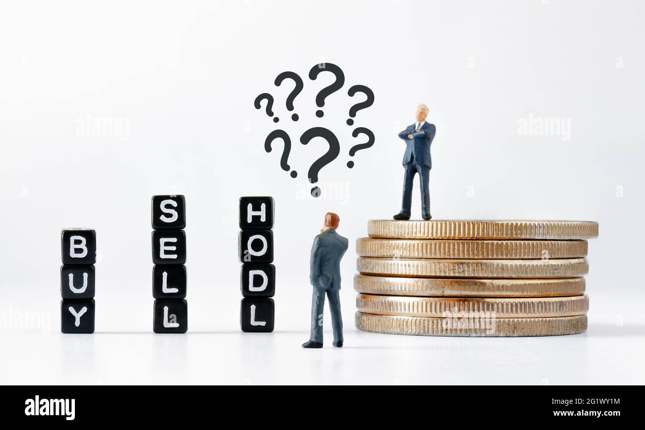 Black cubes with BUY, SELL and HODL text on white background. Thinking businessman figurine with question marks above his head looking at cubes. Stock Photo