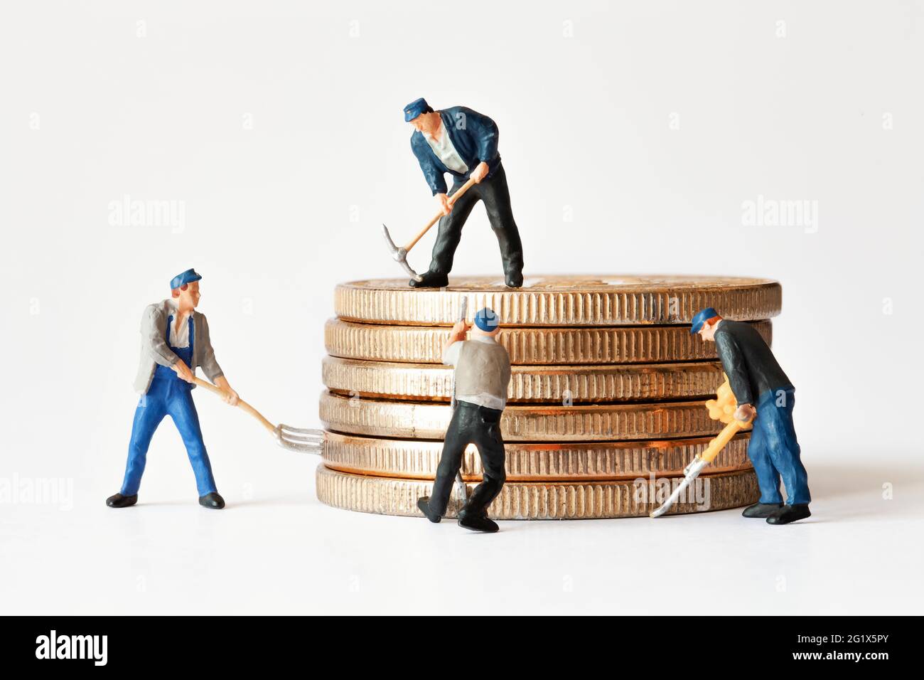 Group of miner figurines with equipment working on stack of bitcoins. Cryptocurrency, blockchain or trading concept. Stock Photo