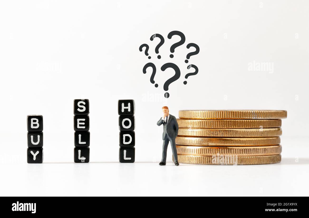 Black cubes with BUY, SELL and HODL text on white background. Thinking businessman figurine with question marks above his head looking at cubes. Stock Photo