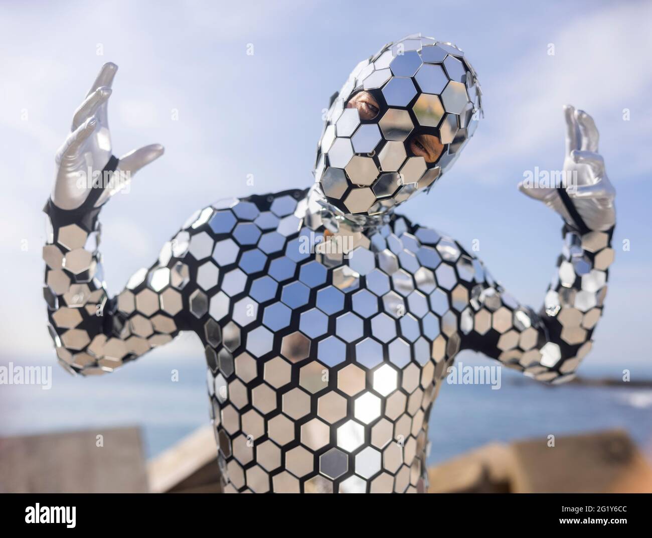 Sparkling discosuit man dancing next to the sea Stock Photo