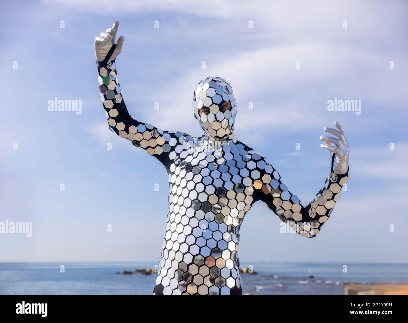 Sparkling discosuit man dancing next to the sea Stock Photo