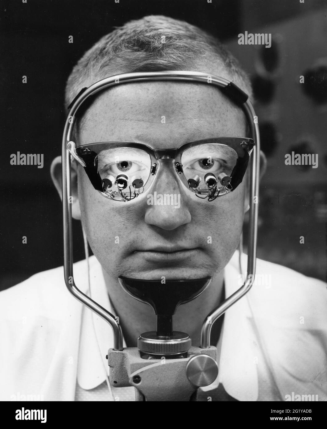 Photoelectric cells mounted on special eyeglasses follow movements of a patient's eyballs as he looks at a moving target, while his head remains motionless. A computer analyzes the findings, thereby aiding physicians in their diagnosis, 1964. (Photo by Authenticated News/ RBM Vintage Images) Stock Photo