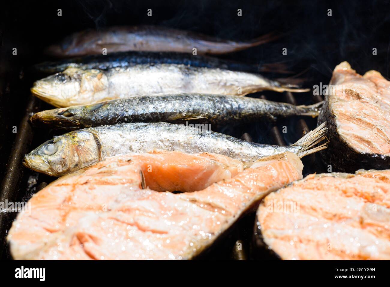 Grilled fresh sardines alongside salmon fillets, great source of