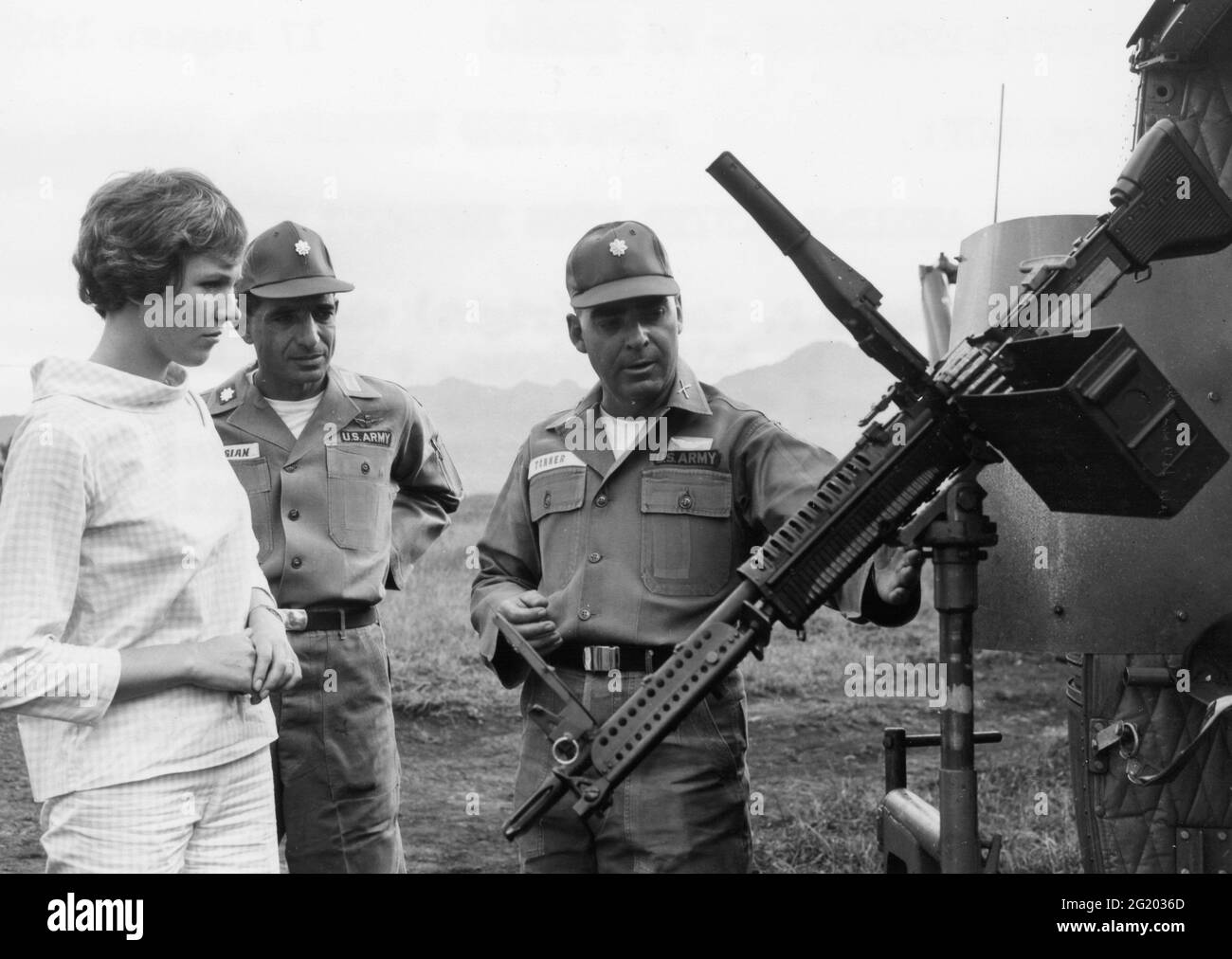 Major Eugene P Tanner (right) shows an M-60 machine gun to Julie Andrews, star of 'Mary Poppins' and 'Sound of Music' during her visit to the 25th Infantry Division. In the center is Lt Col Samuel P Kalagian, commanding officer, 25th Aviation Battalion, Schofield Barracks, HI, 8/17/1965. (Photo by Sp5 Jack Thompson/US Army/RBM Vintage Images) Stock Photo