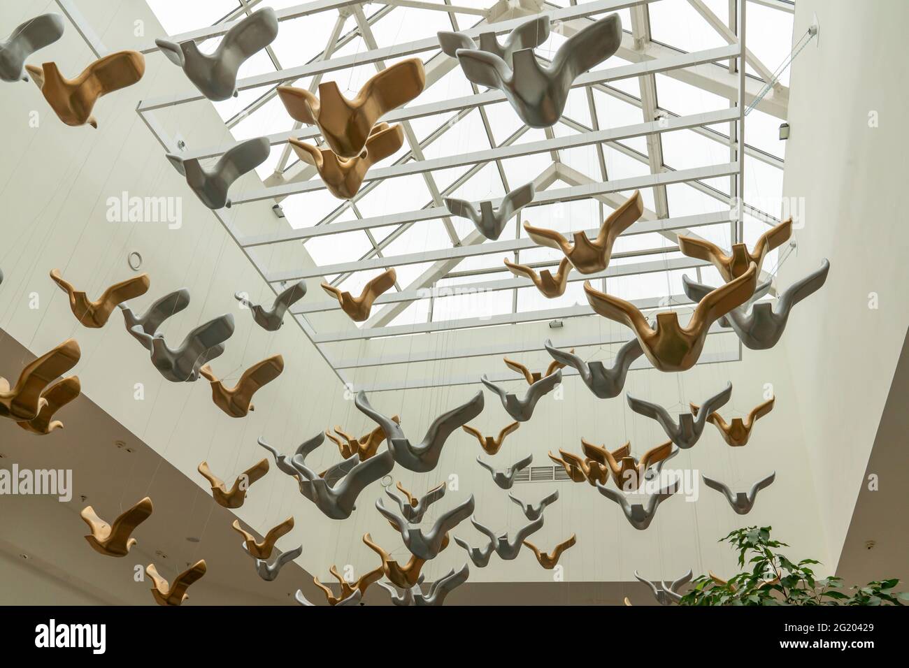 golden and metal birds - a fragment of a modern art installation in a shopping center. A symbol of freedom and love. Hypermarket Planet. Krasnoyarsk, Stock Photo