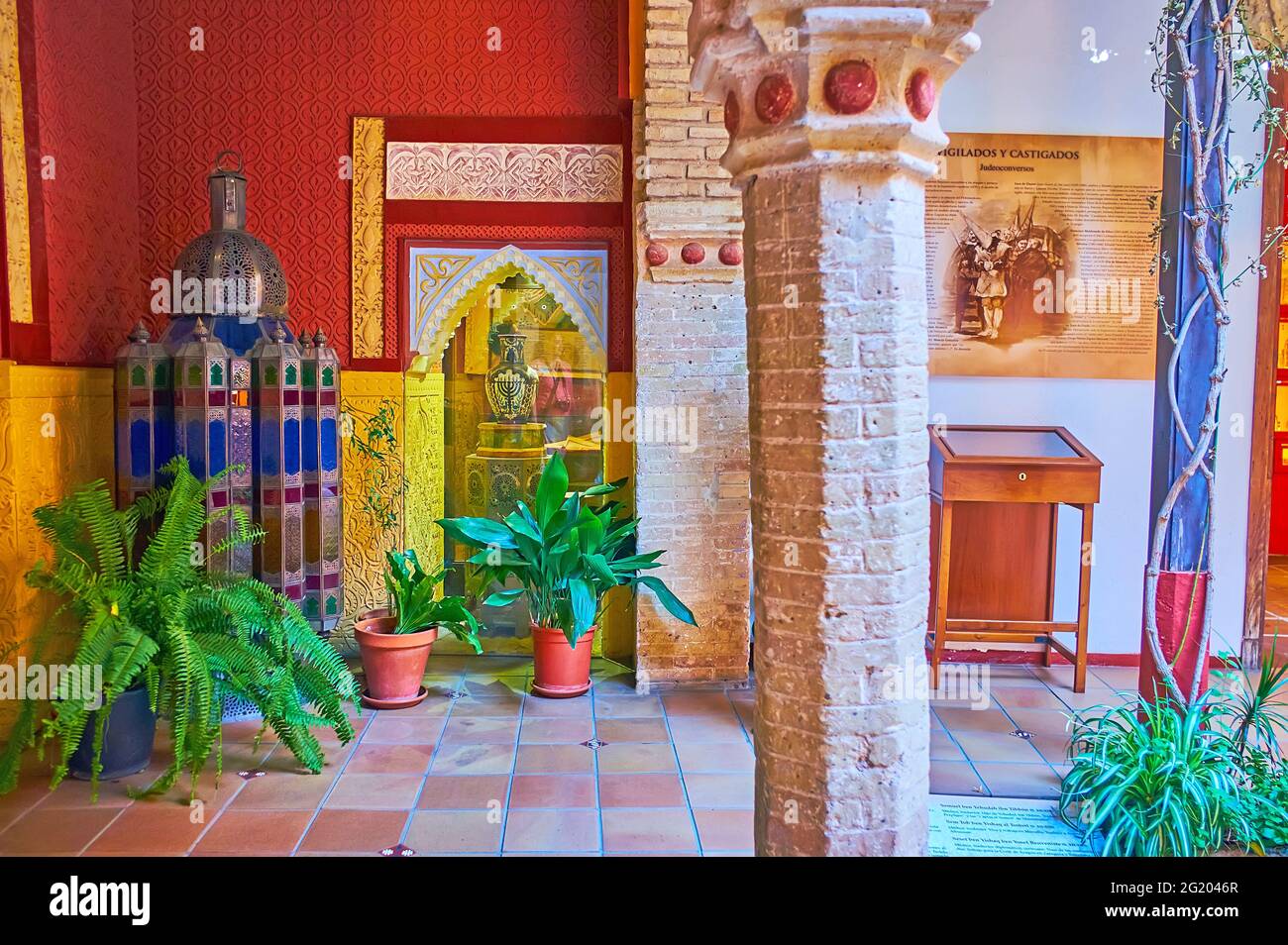 CORDOBA, SPAIN - SEPTEMBER 30, 2019: The richly decorated walls, old brick columns and plants in pots in Casa de Sefarad, Juderia (Jewish Quarter), on Stock Photo