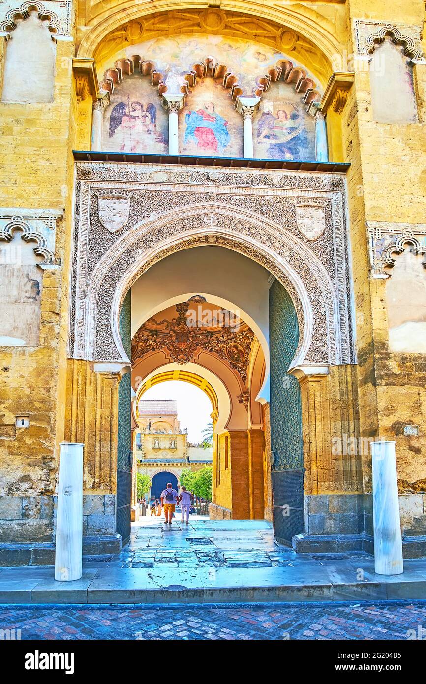 CORDOBA, SPAIN - SEP 30, 2019: The ornate horseshoe arch of Door of Forgiveness (Puerta del Perdon) with blind arcade of polylobed arches with frescoe Stock Photo