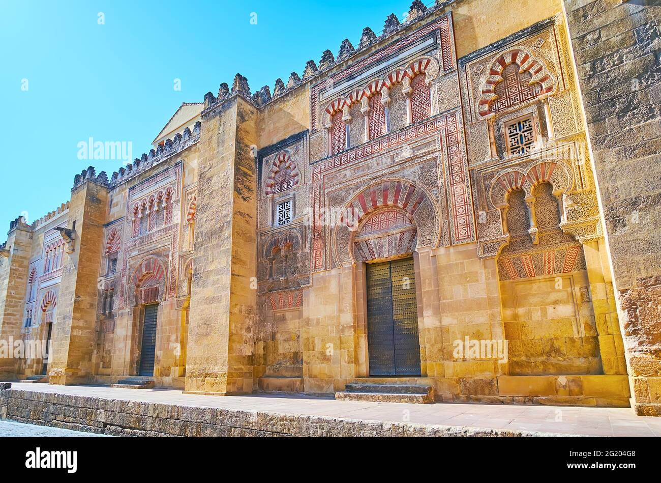 The massive outer wall of Mezquita with preserved medieval gates: Puerta de San Jose, Puerta de la Concepcion Antigua, Puerta de San Nicolas, richly d Stock Photo