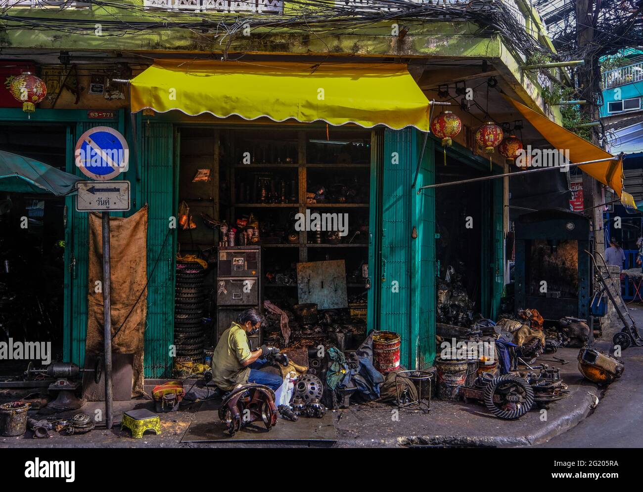 A male worker works outside his workshop in Talat Noi, Bangkok, Thailand Stock Photo