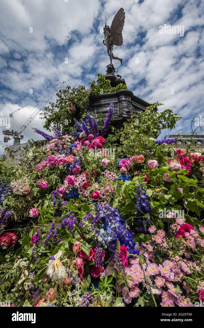 Foral guru, Lewis Miller, and royal florist Simon Lycett 'create a positive, emotional response through flowers' in London around the anteros statue. Stock Photo