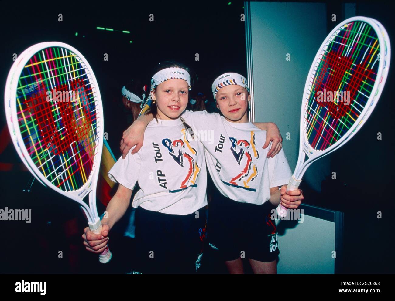 Two girls with large tennis rackets wearing the ATP tour T-shirt, USA 1993 Stock Photo