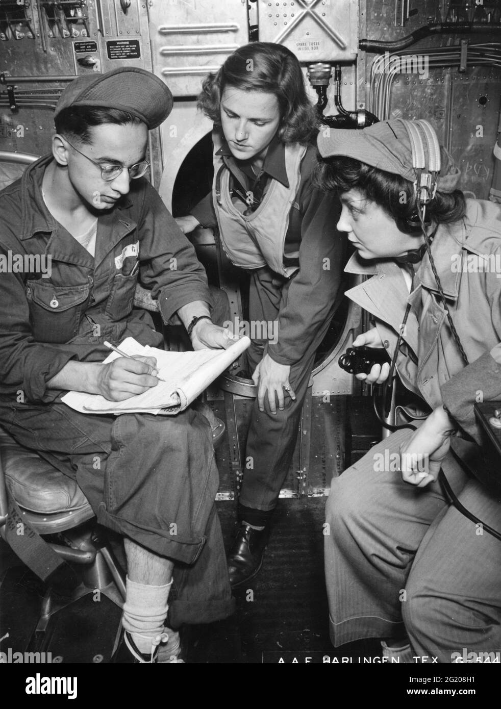 WASP Jeanne d'Ambly (center) checks the flight paperwork with her engineer, Cpl George J Brown and her radio operator, Cpl Helen Mehegan before taking a Martin B-26 aloft at Harlingen AAF, Harlingen, TX, circa 1944. (Photo by US Army Air Force/RBM Vintage Images) Stock Photo