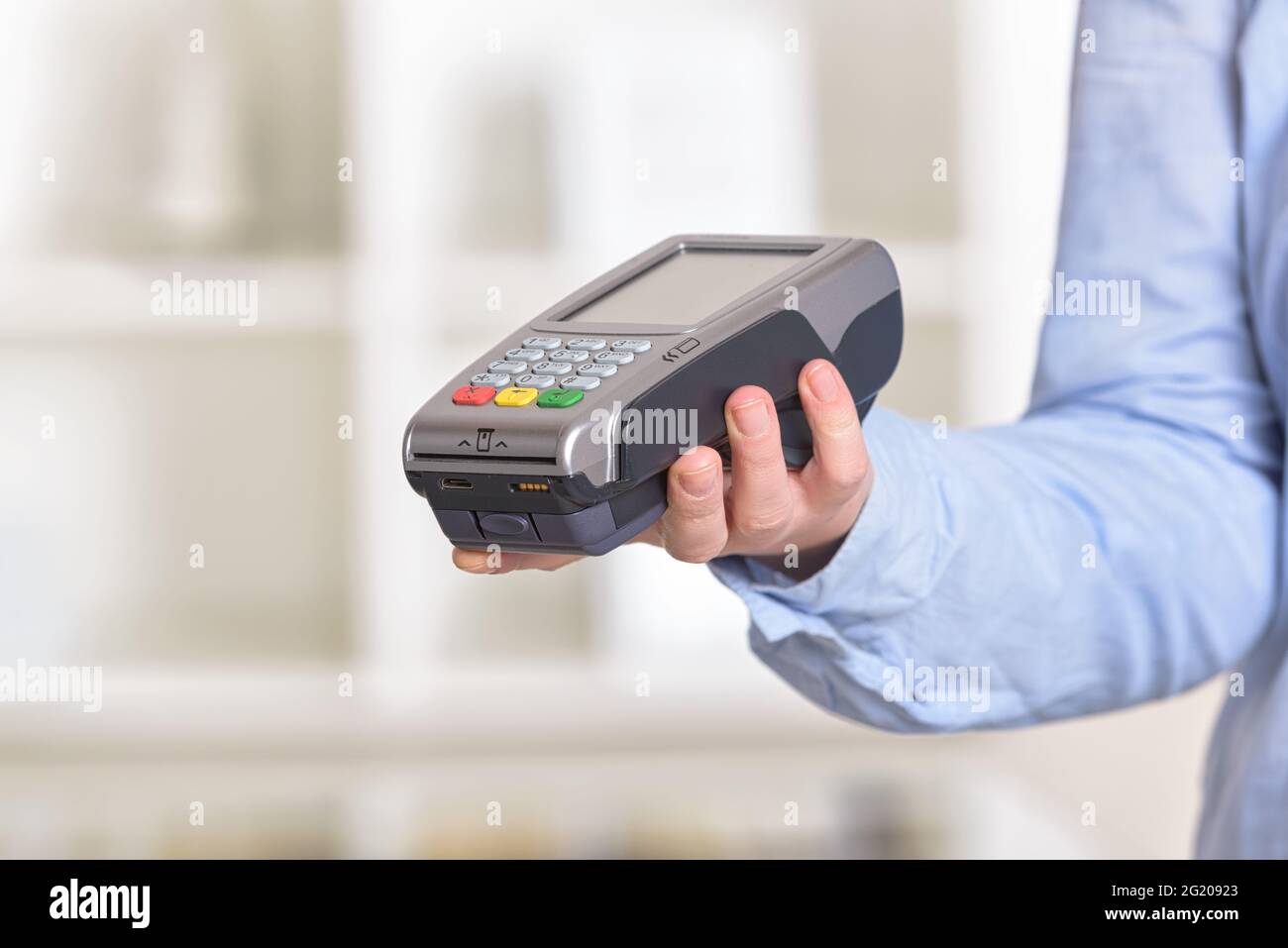 A hand holding a wireless card payment terminal at shop Stock Photo - Alamy