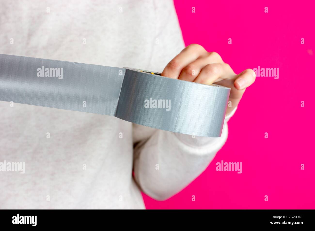 Roll of sticky tape in hands. Packing the parcel with adhesive tape. Tearing off the adhesive