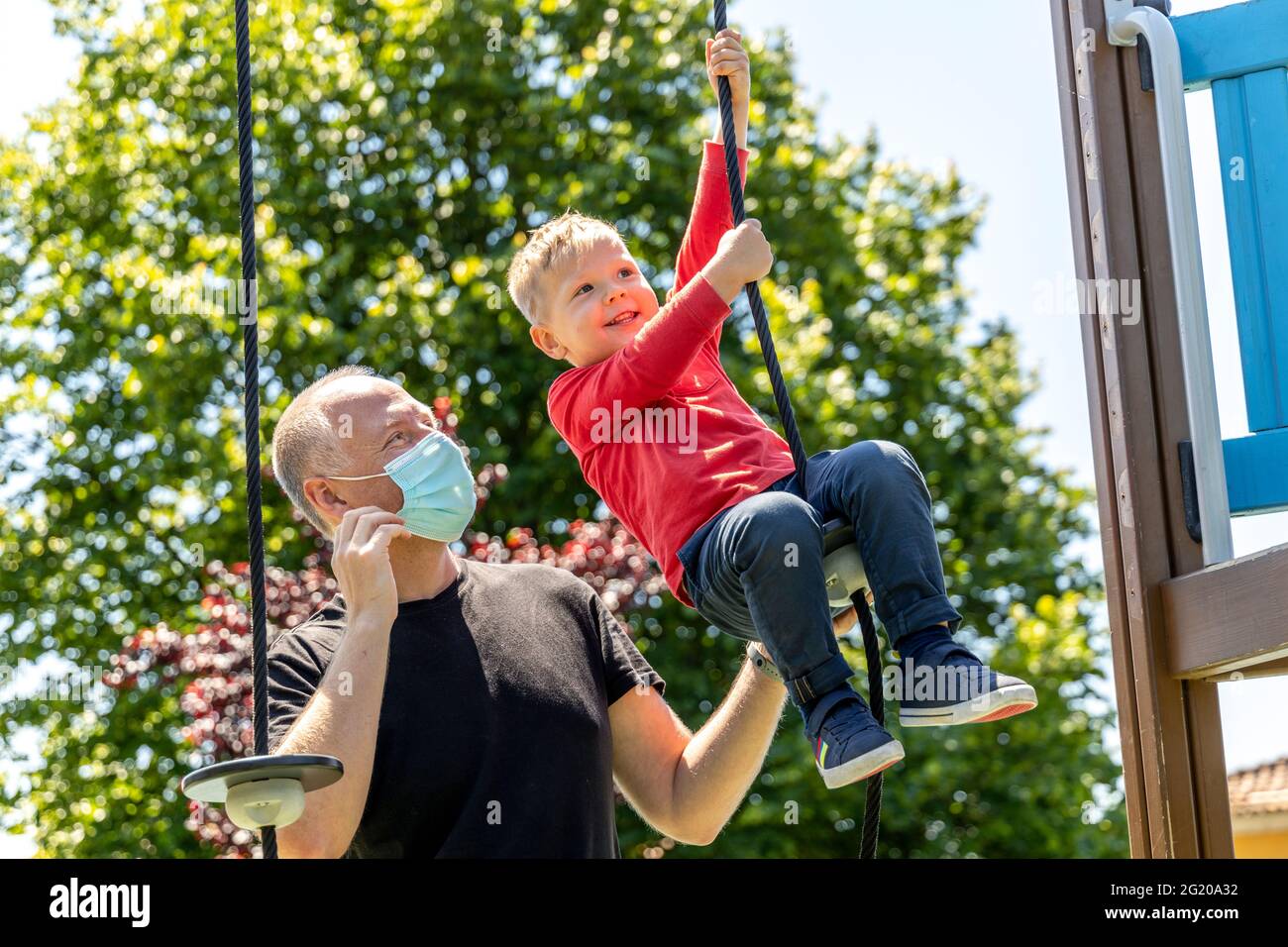 Father playing with his 3 years old son on the playground Stock Photo
