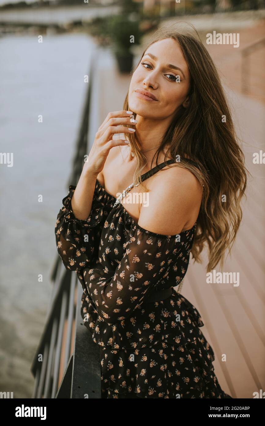 Pretty young long hair brunette woman standing on the riverside Stock ...